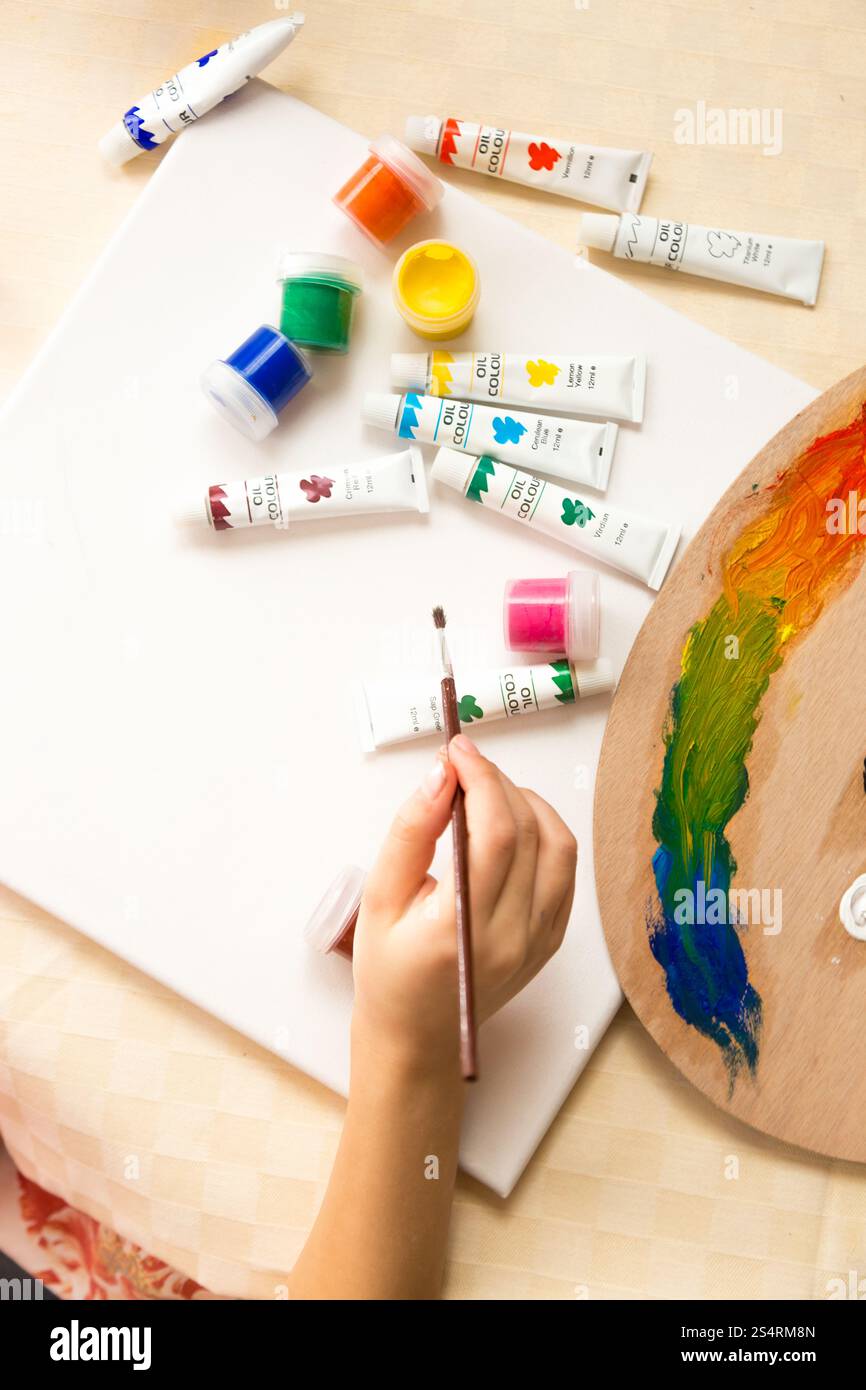 Vue de dessus sur girl holding paintbrush et dessin de la peinture à l'huile Banque D'Images