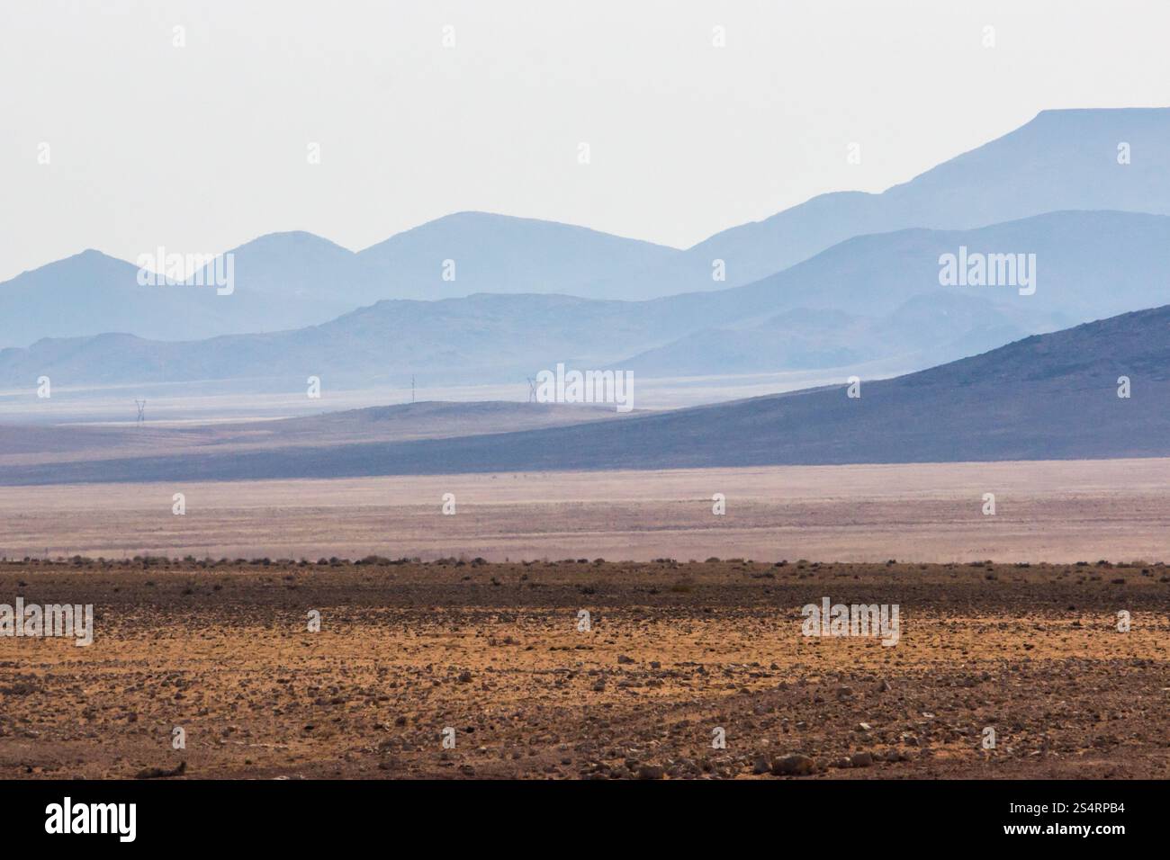 Montagnes bleues lointaines avec le paysage aride et aride d'Aus, Namibie, au premier plan. Banque D'Images