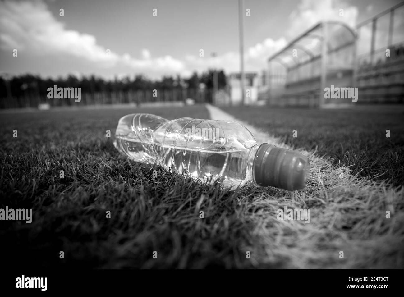 Tourné en noir et blanc d'une bouteille d'eau se trouvant sur le terrain de soccer Banque D'Images