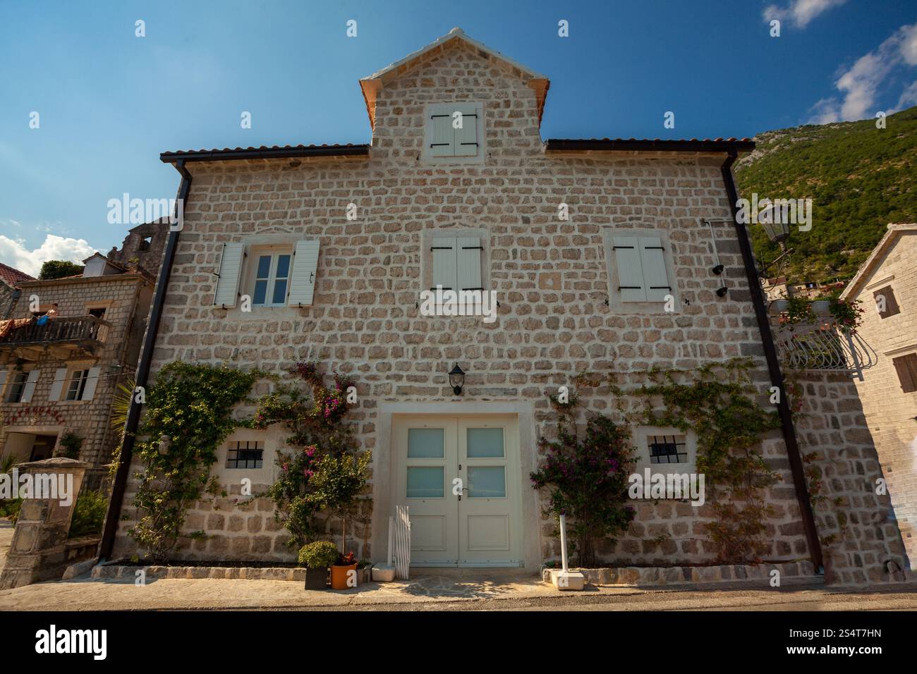 Bel immeuble ancien avec des fenêtres et portes en bois blanc en ville de Perast Banque D'Images