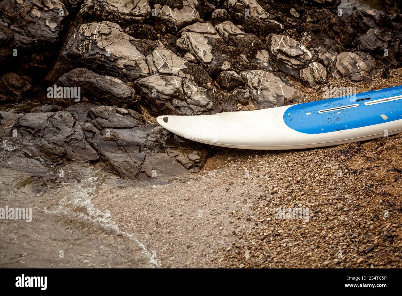 Photo gros plan de surf sur sable à côté de la mer falaises déchiquetées Banque D'Images