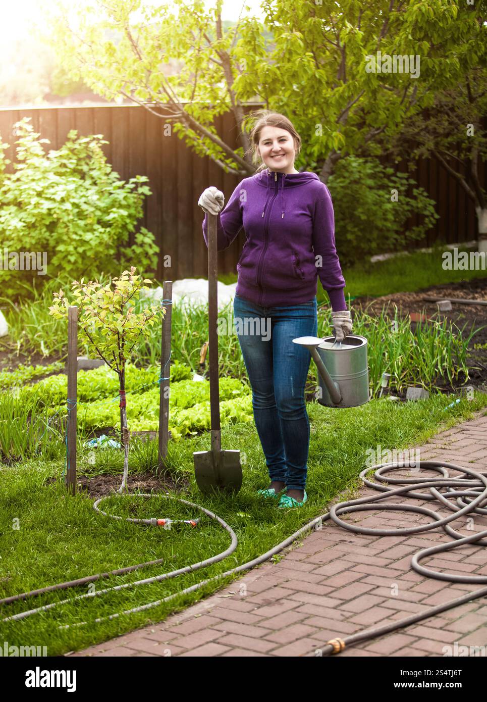 Happy smiling woman with garden outils à jour ensoleillé Banque D'Images