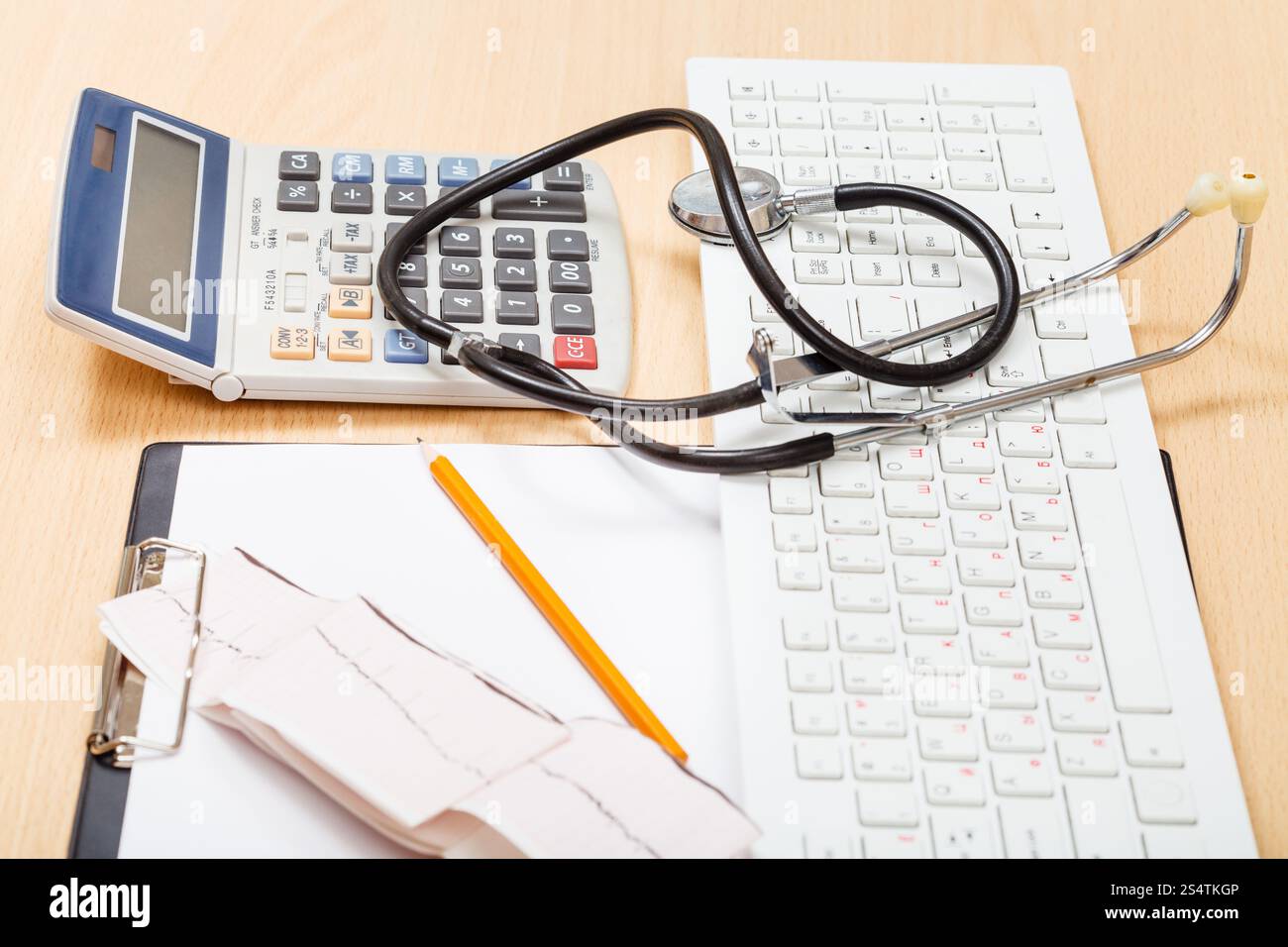 Phonendoscope, clavier blanc, calculatrice, ECG et les presse-papiers en blanc sur la table Banque D'Images
