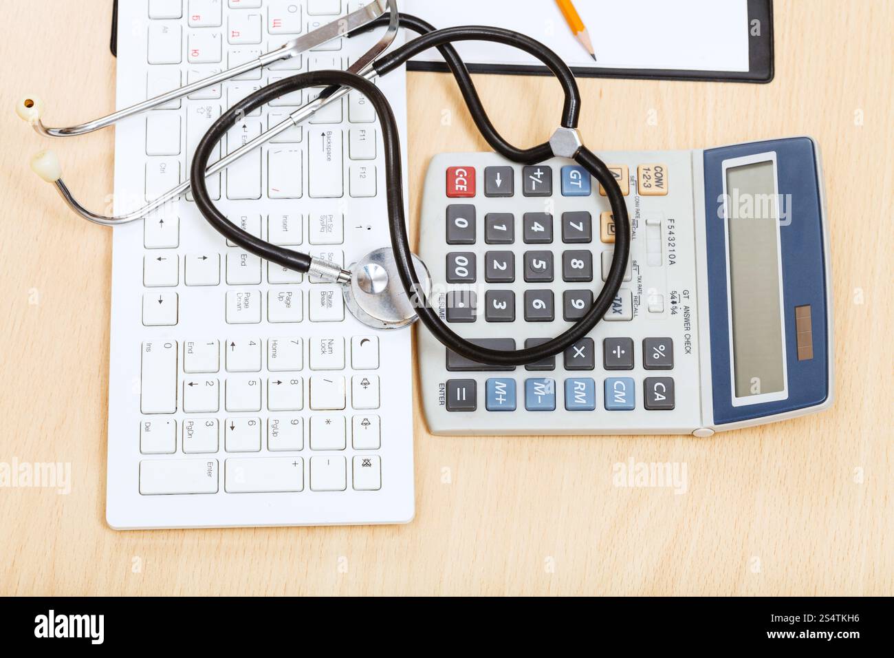 Medical still life - stéthoscope sur clavier blanc, calculatrice et presse-papiers vierges Banque D'Images