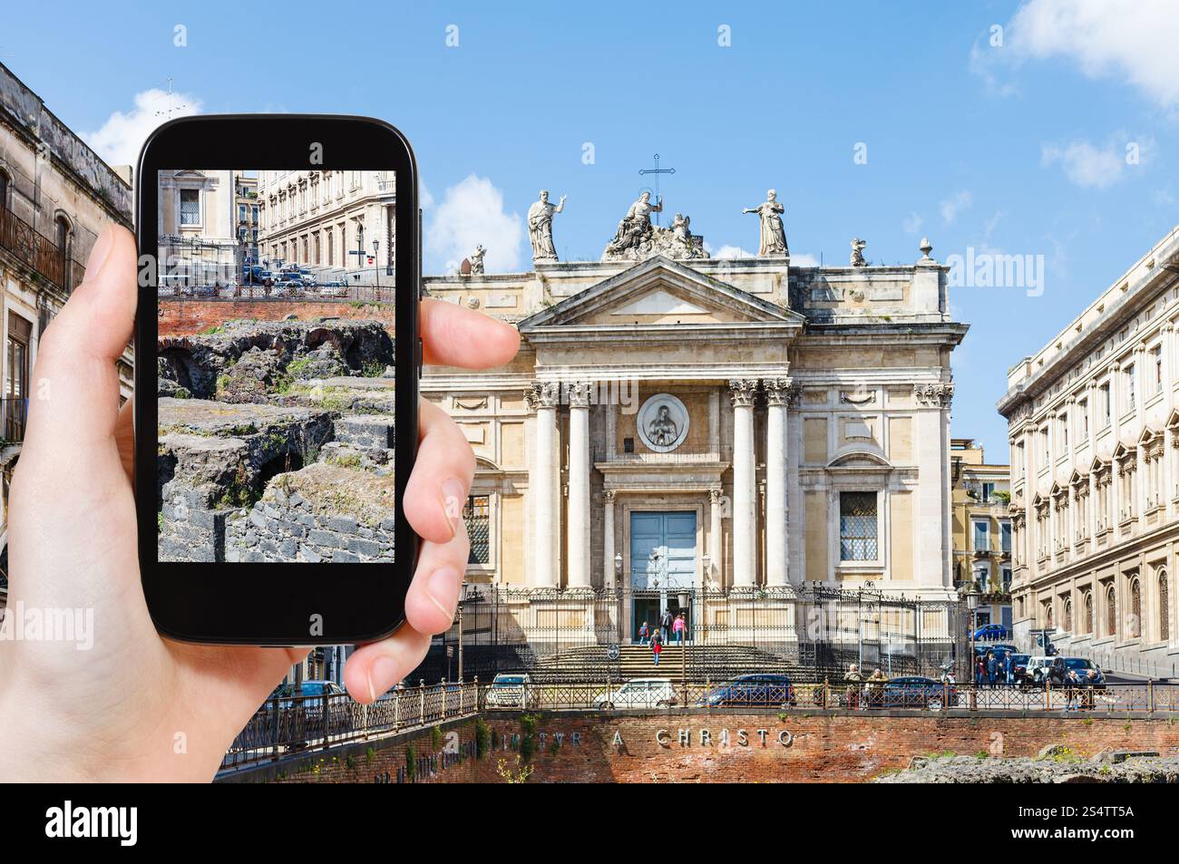 Concept de voyage - touriste prend des photos de l'ancien amphithéâtre romain (Anfiteatro Romano) et l'église San Biagio sur la Piazza Stesicoro à Catane, Sicile Banque D'Images