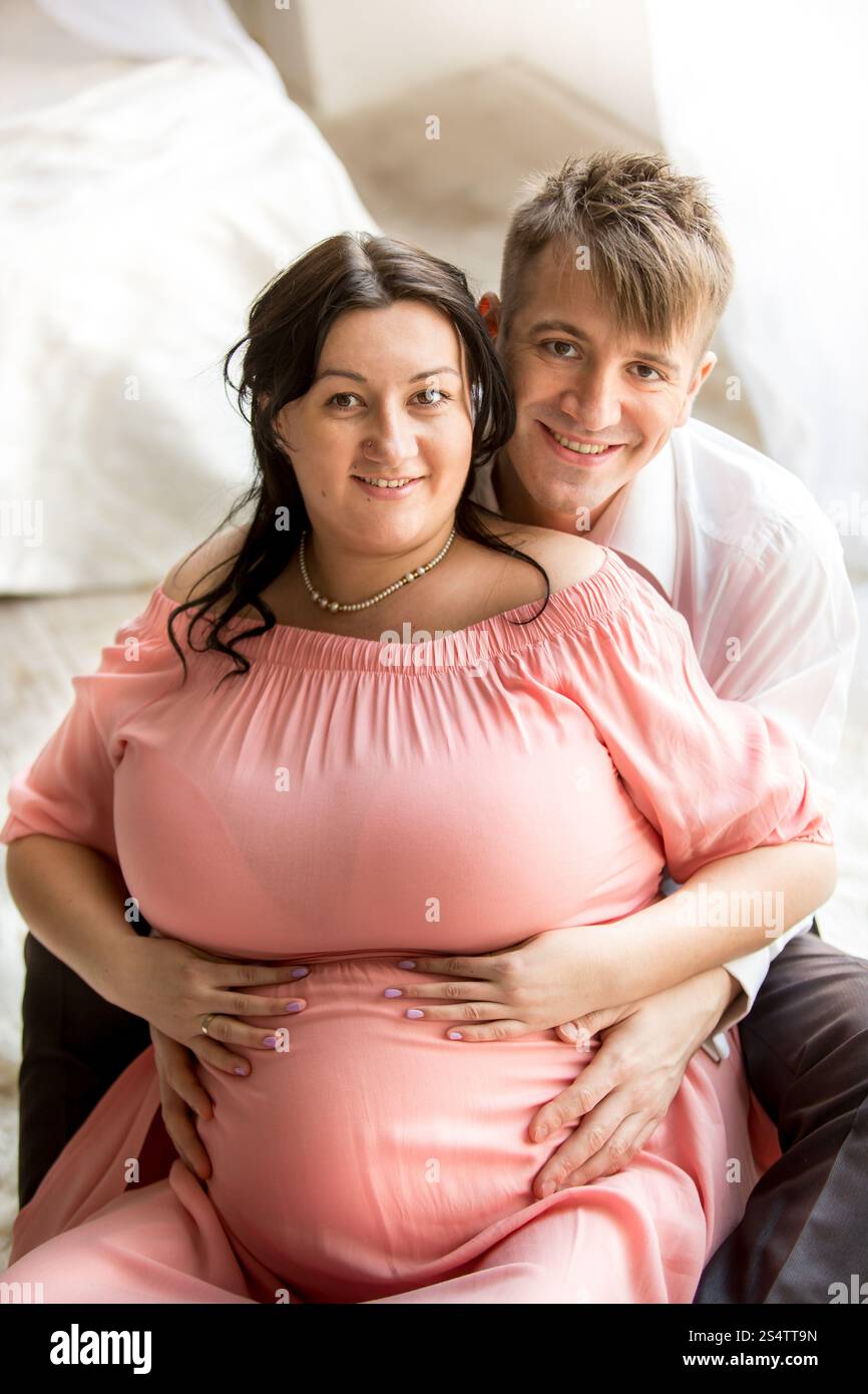 Portrait of handsome man hugging pregnant chubby de retour Banque D'Images