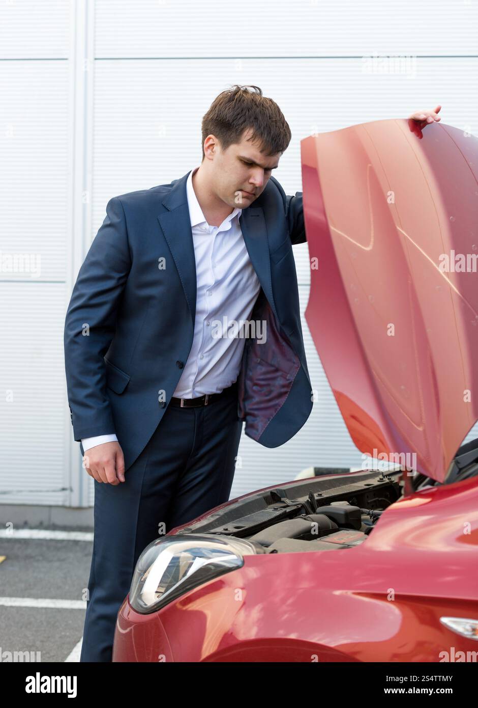 Homme regardant sous le capot de la voiture Banque de photographies et ...