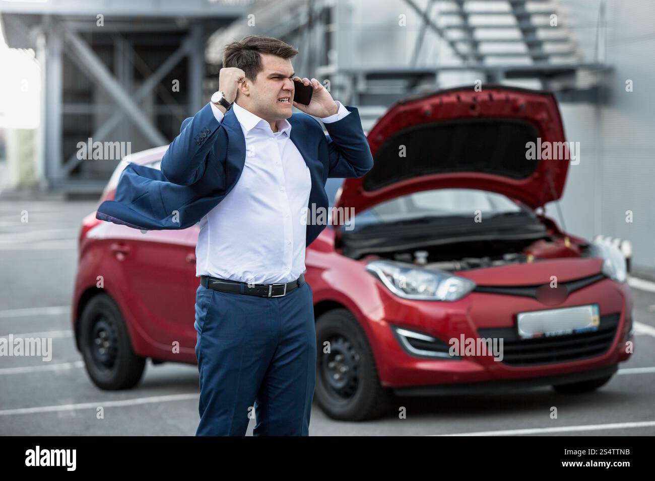 Homme en colère en criant à cause de Téléphone de voiture cassée Banque D'Images