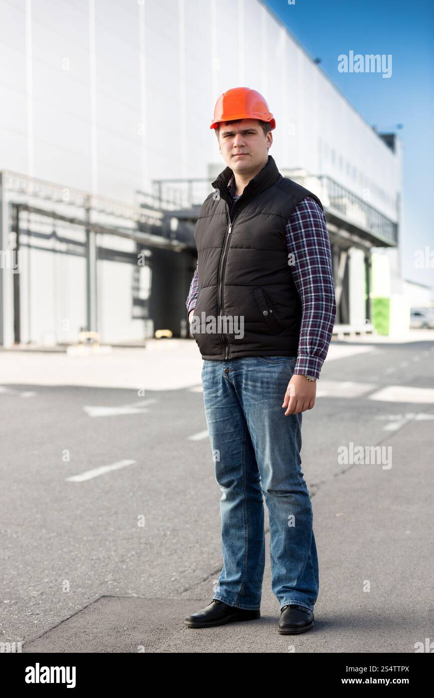 Portrait de l'ingénieur beau posing contre grand entrepôt Banque D'Images