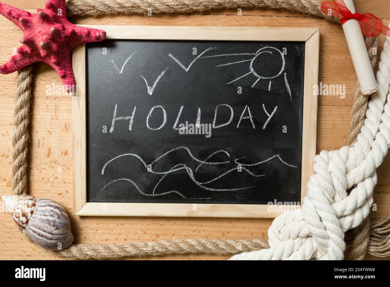 Word Holiday' écrit sur tableau noir décoré par des coquillages et des nœuds marins' Banque D'Images