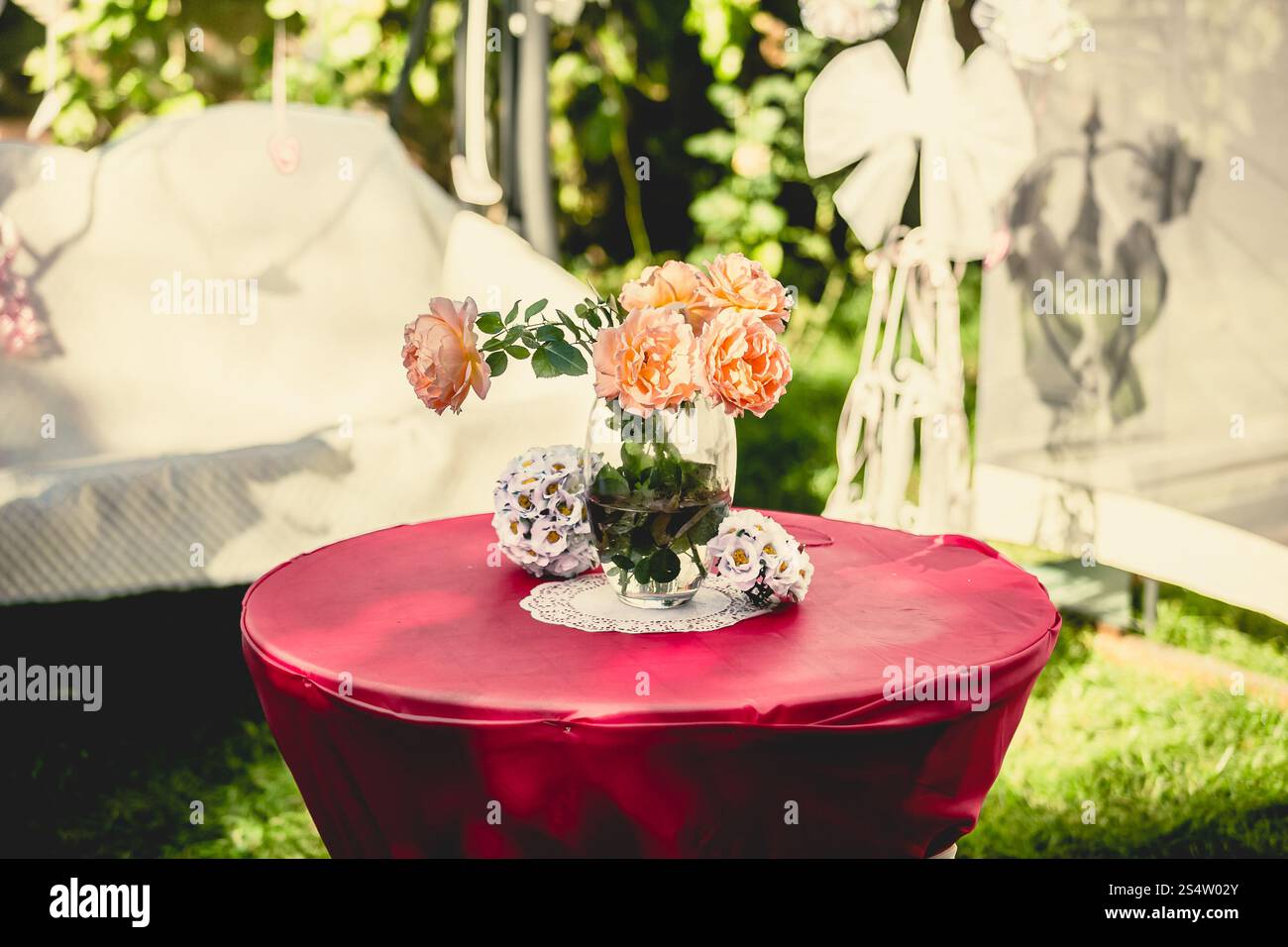 Gros plan photo tonique de vase avec des roses debout table à la journée ensoleillée Banque D'Images
