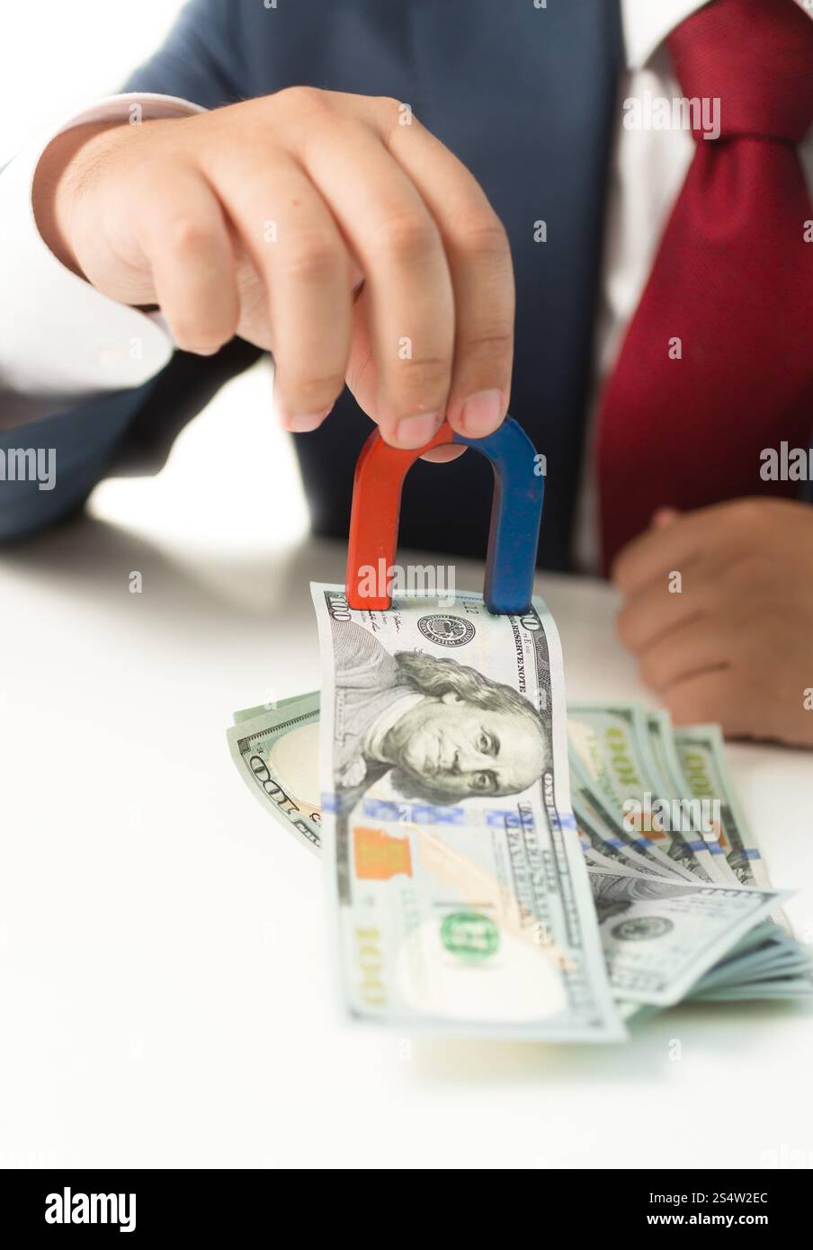 Shot of businessman holding conceptuel aimant et d'encombrement de l'argent de la table Banque D'Images