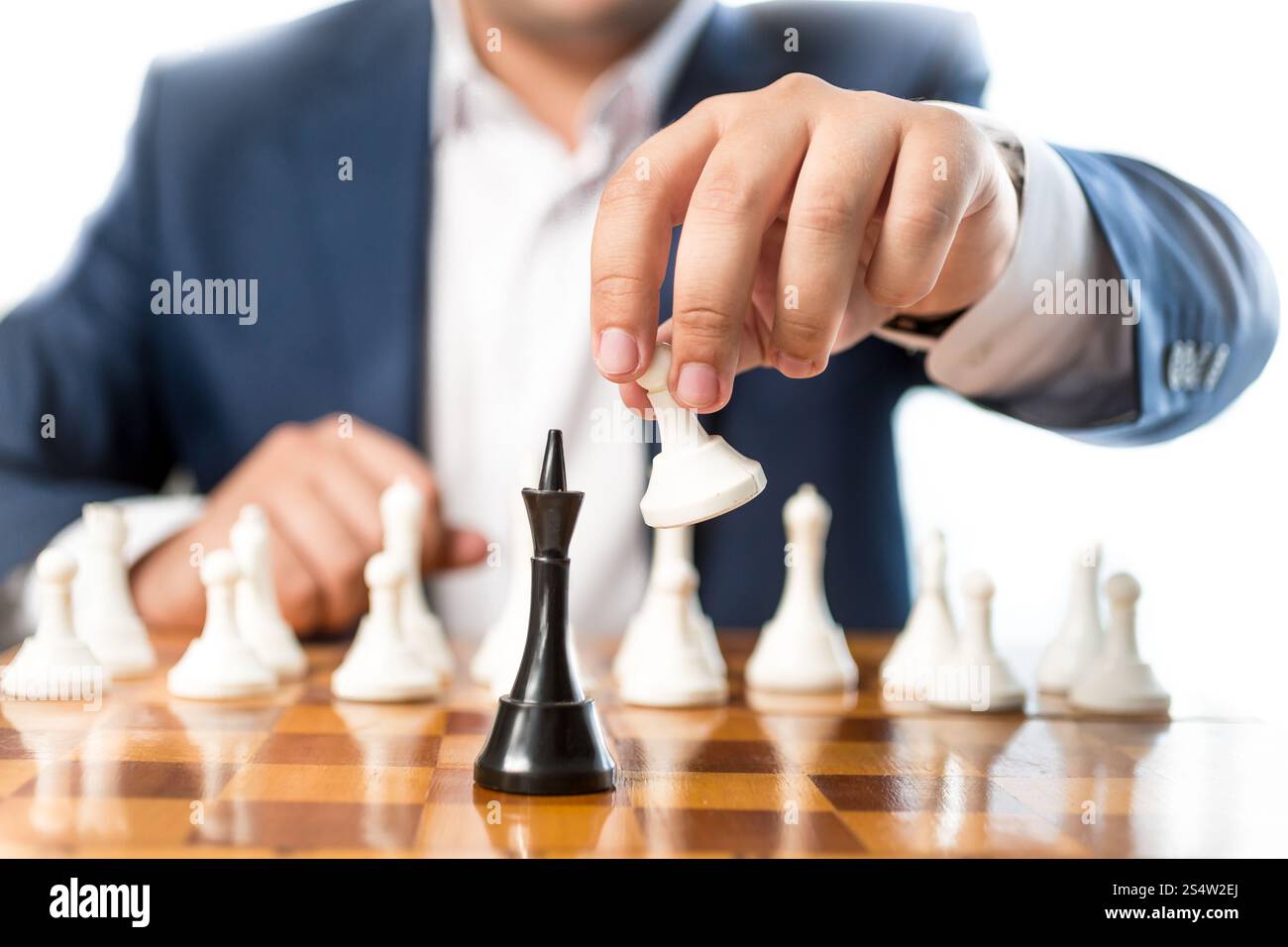 Photo gros plan de businessman jouer aux échecs et à battre roi noir Banque D'Images