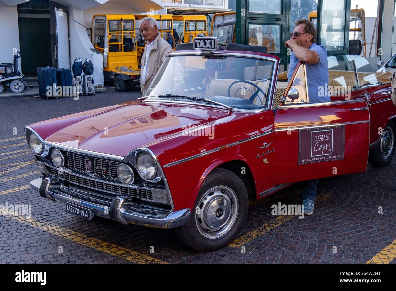 Un chauffeur de taxi avec son taxi cabriolet Fiat 1500 vintage des années 1960 personnalisé dans la ville de Capri, Italie. Banque D'Images