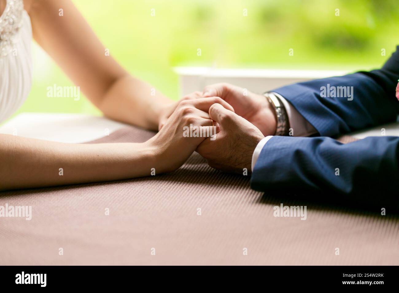 Gros plan photo de mariée et mariée tenant les mains sur la table au restaurant Banque D'Images