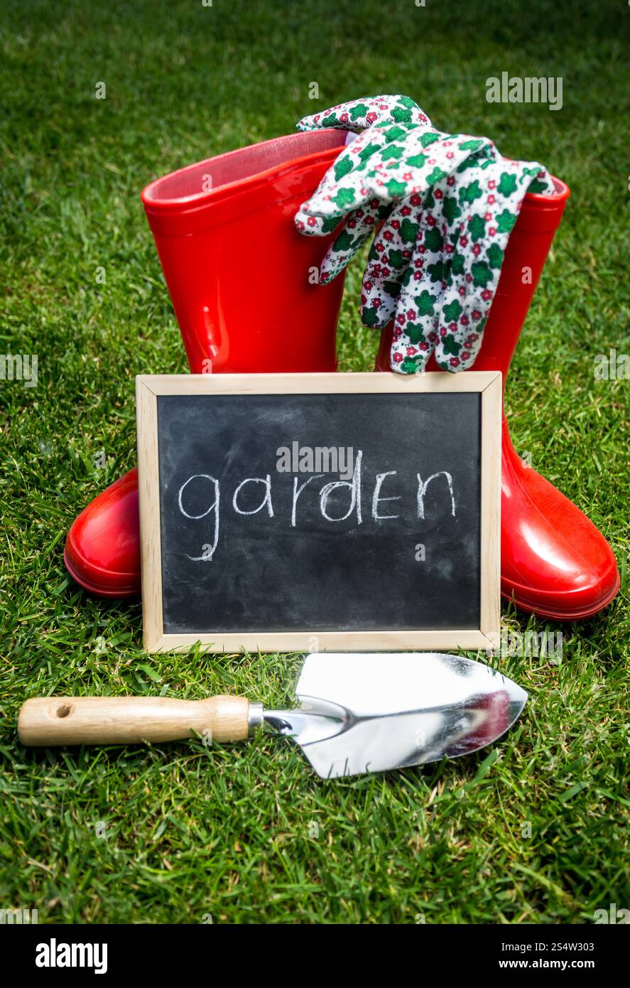 Gros plan photo d'outils de jardin et tableau noir avec le mot Garden 'on green grass' Banque D'Images