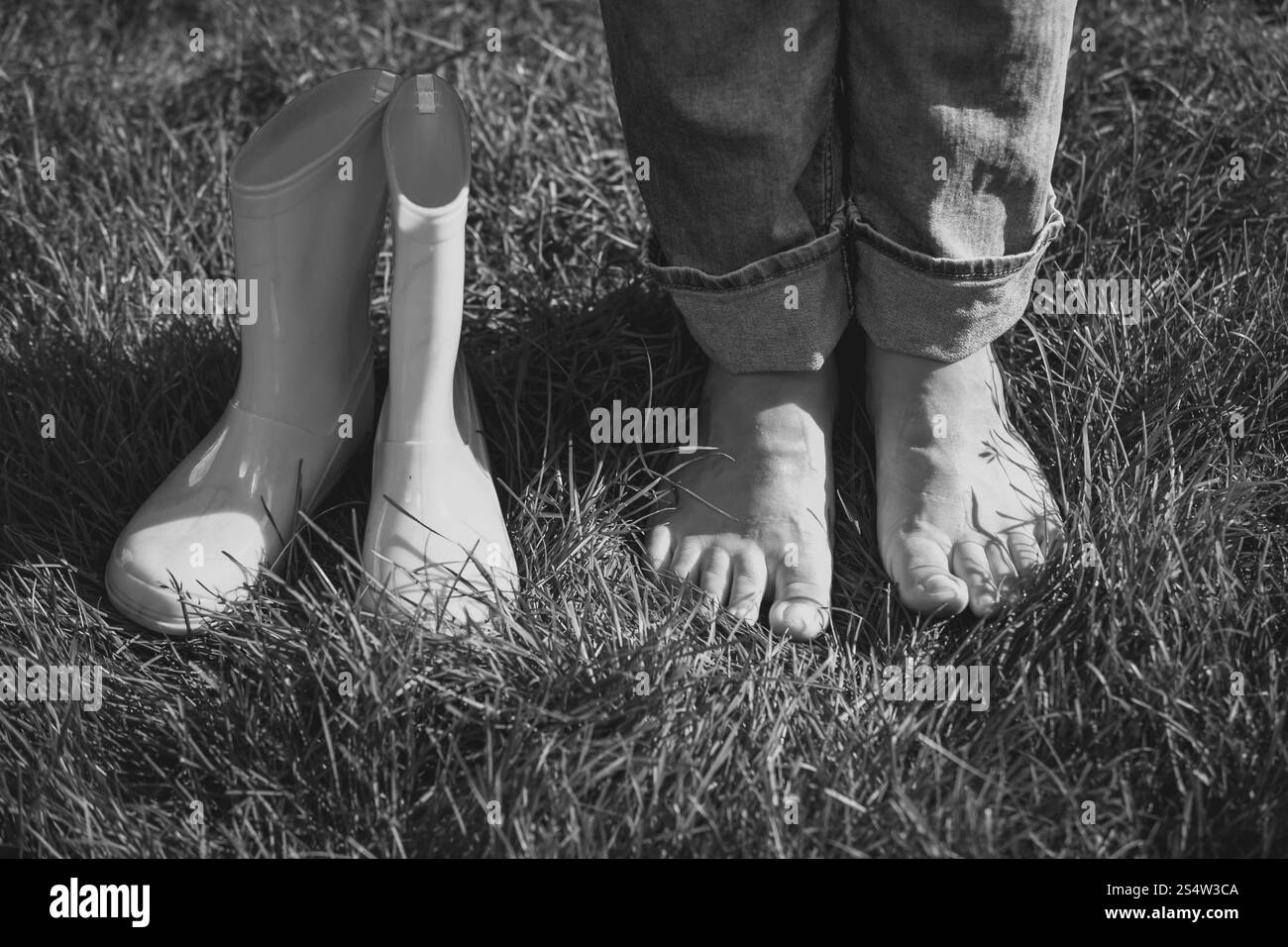 Photo en noir et blanc de fille a décollé les endurants et Comité permanent sur l'herbe Banque D'Images