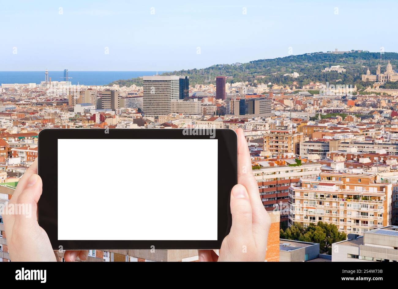 Concept de voyage - photographie touristique Barcelone ville et colline Montjuic, Espagne dans la soirée sur tablette pc avec écran découpé avec place vide pour Banque D'Images