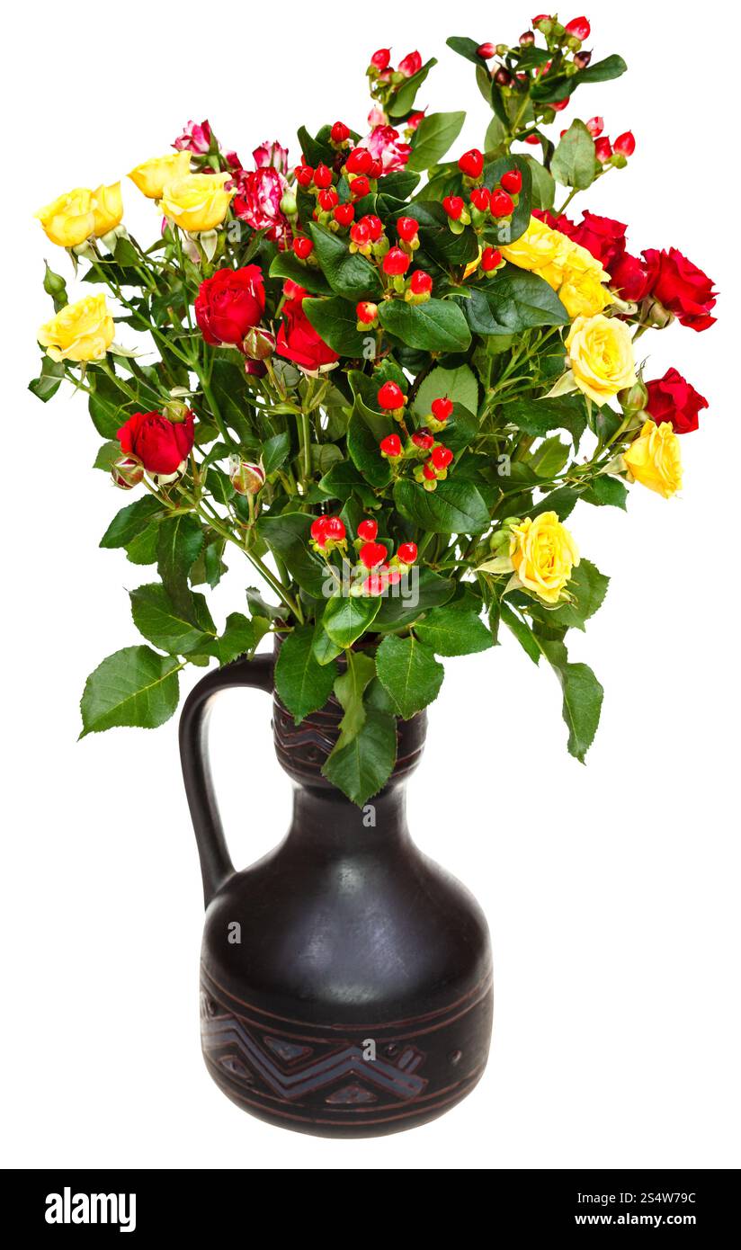 roses jaunes, rouges et fleurs hypericum dans une cruche en céramique sur fond blanc Banque D'Images