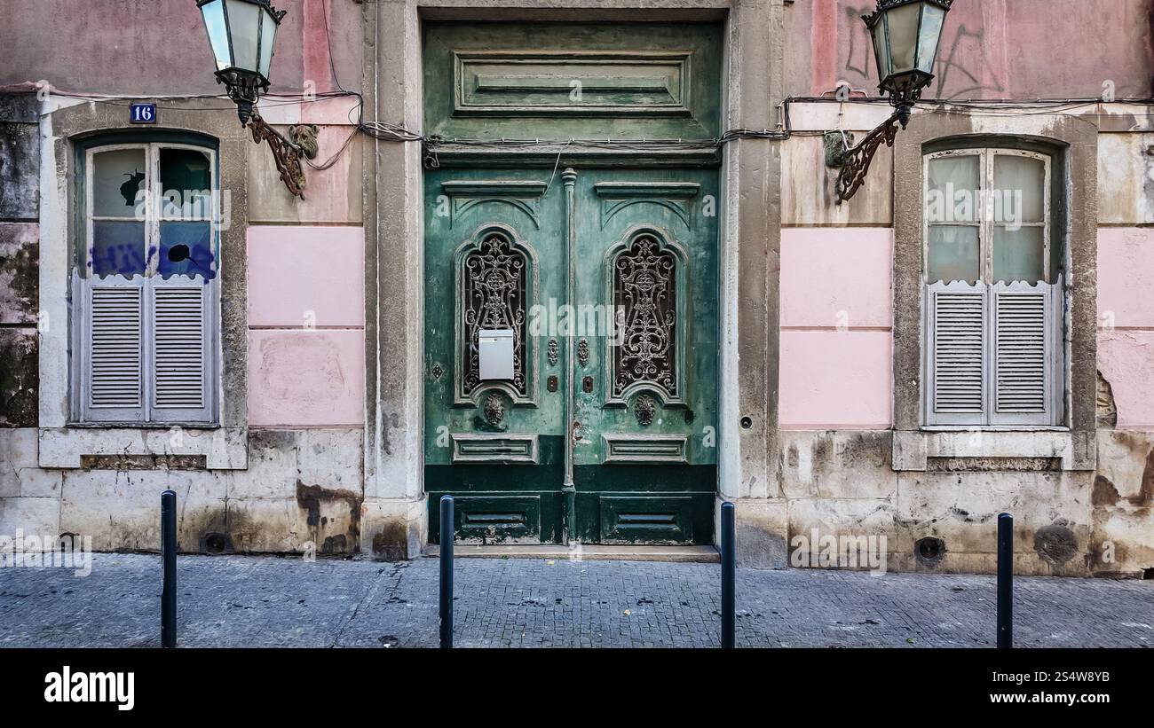 Un vieux bâtiment à Lisbonne avec un ensemble de portes vertes, mettant en valeur l'architecture portugaise traditionnelle et le charme historique Banque D'Images