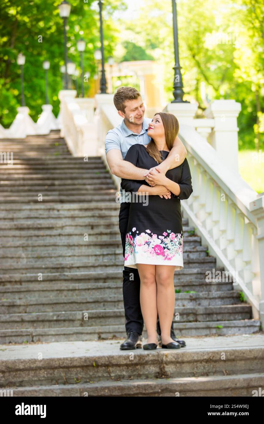 Beau couple amoureux serrant dans les escaliers en pierre au parc Banque D'Images