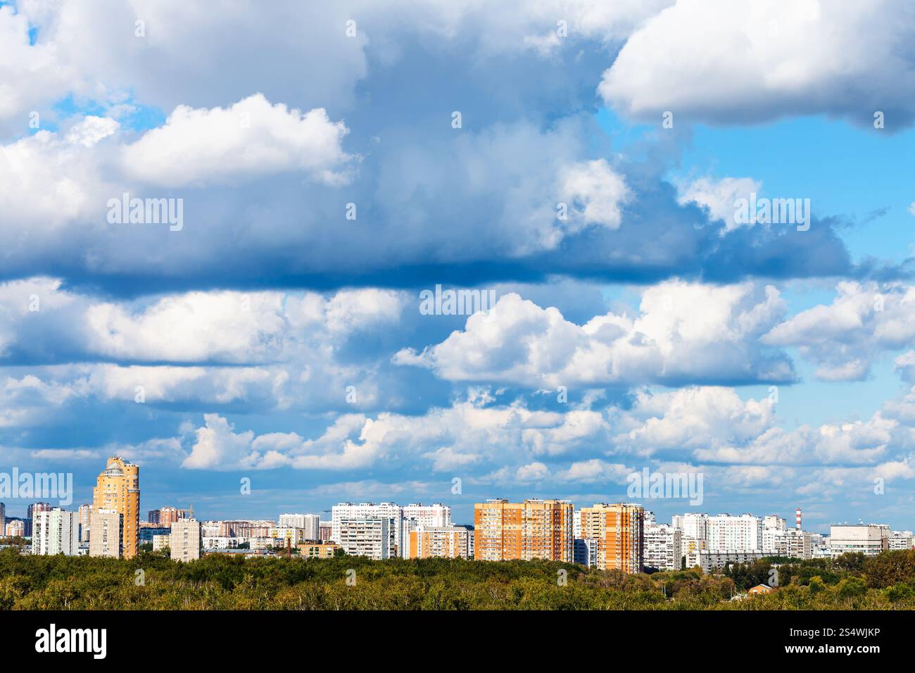 Bleu faible nuages sur bois verts et les immeubles à appartements en été Banque D'Images Bleu faible nuages sur bois verts et les immeubles à appartements en été Banque D'Images