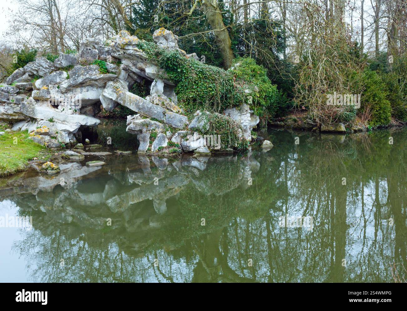 Parc de printemps avec étang et arbres reflétant sur la surface de l'eau. Banque D'Images