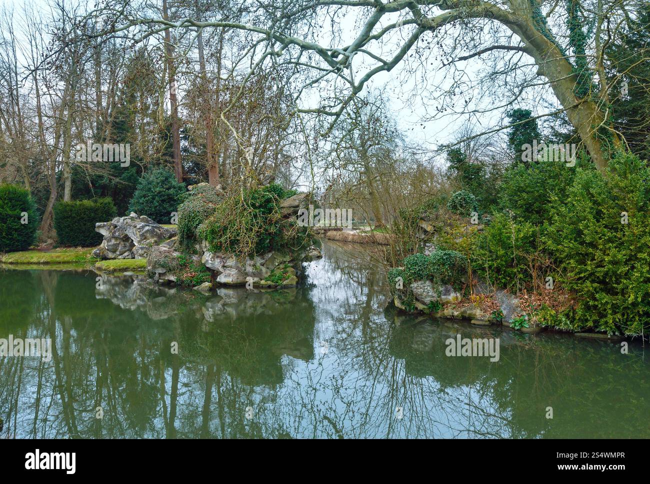 Parc de printemps avec étang et arbres reflétant sur la surface de l'eau. Banque D'Images