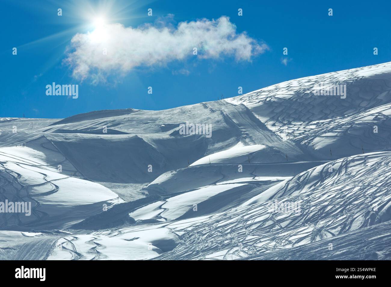 Pistes de ski paniqué à flanc de colline, avec du soleil et seul nuage dans le ciel bleu. L'hiver l'Autriche. Banque D'Images
