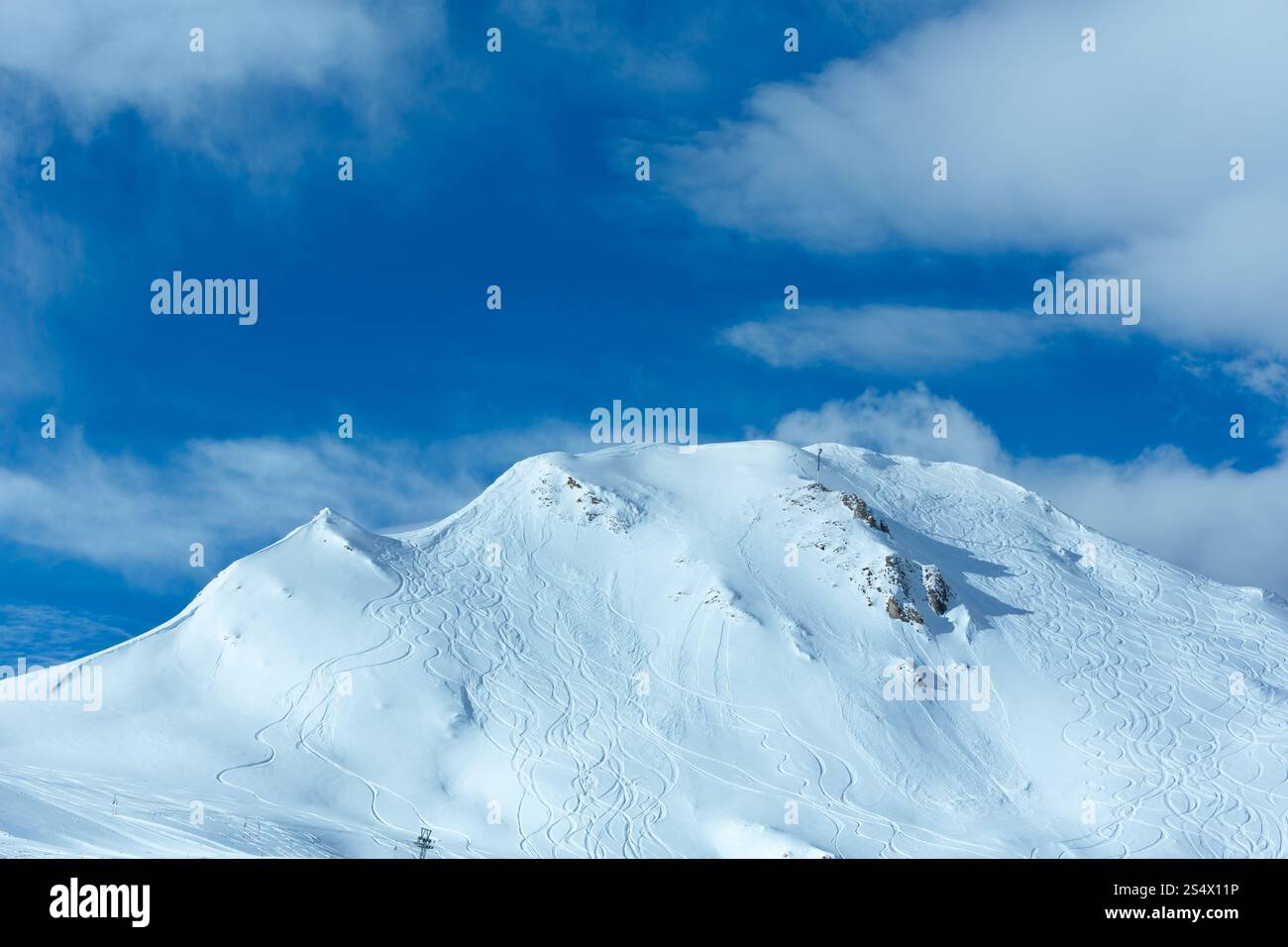 Les pistes de ski de Hillside ondulent et nuages dans le ciel bleu. L'hiver l'Autriche. Banque D'Images