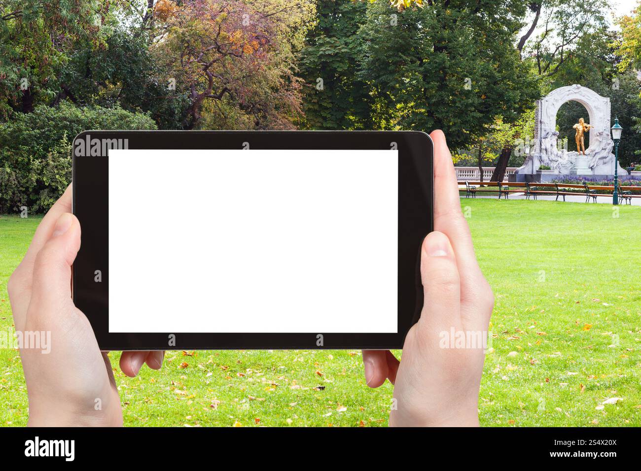Concept de voyage - photographies touristiques pelouse verte et Johann Strauss dans Stadtpark (City Park) à Vienne sur tablette pc avec écran découpé avec blanc Banque D'Images