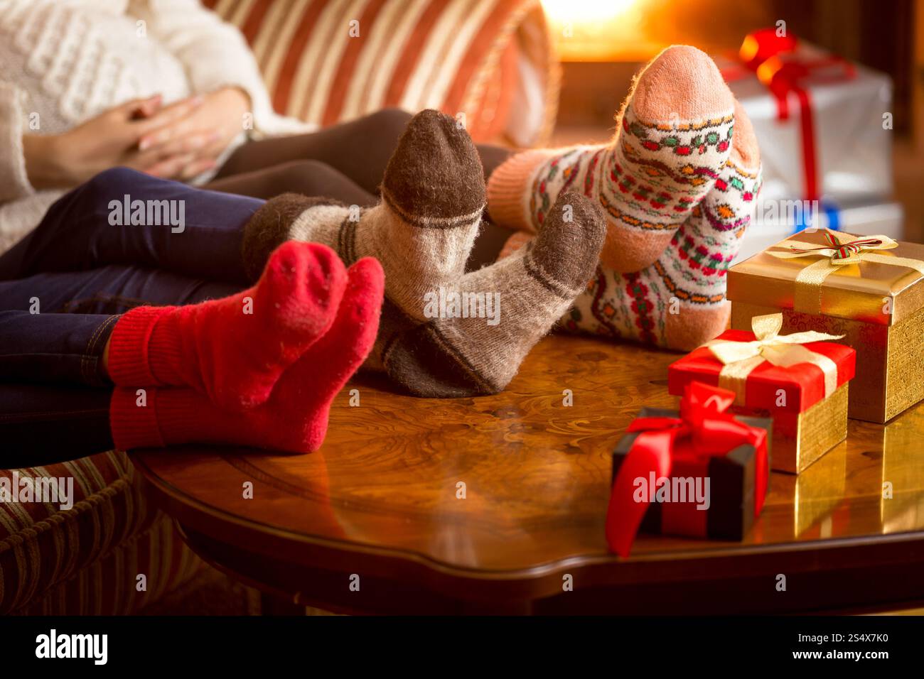 Gros plan photo de familles jambes dans des chaussettes en laine à côté de la cheminée à Noël Banque D'Images Gros plan photo de familles jambes dans des chaussettes en laine à côté de la cheminée à Noël Banque D'Images