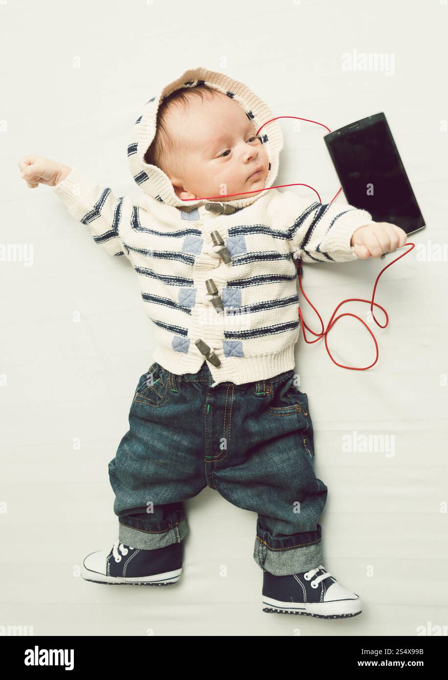 Photo de ton mignon bébé garçon écouter la musique avec vos écouteurs Banque D'Images