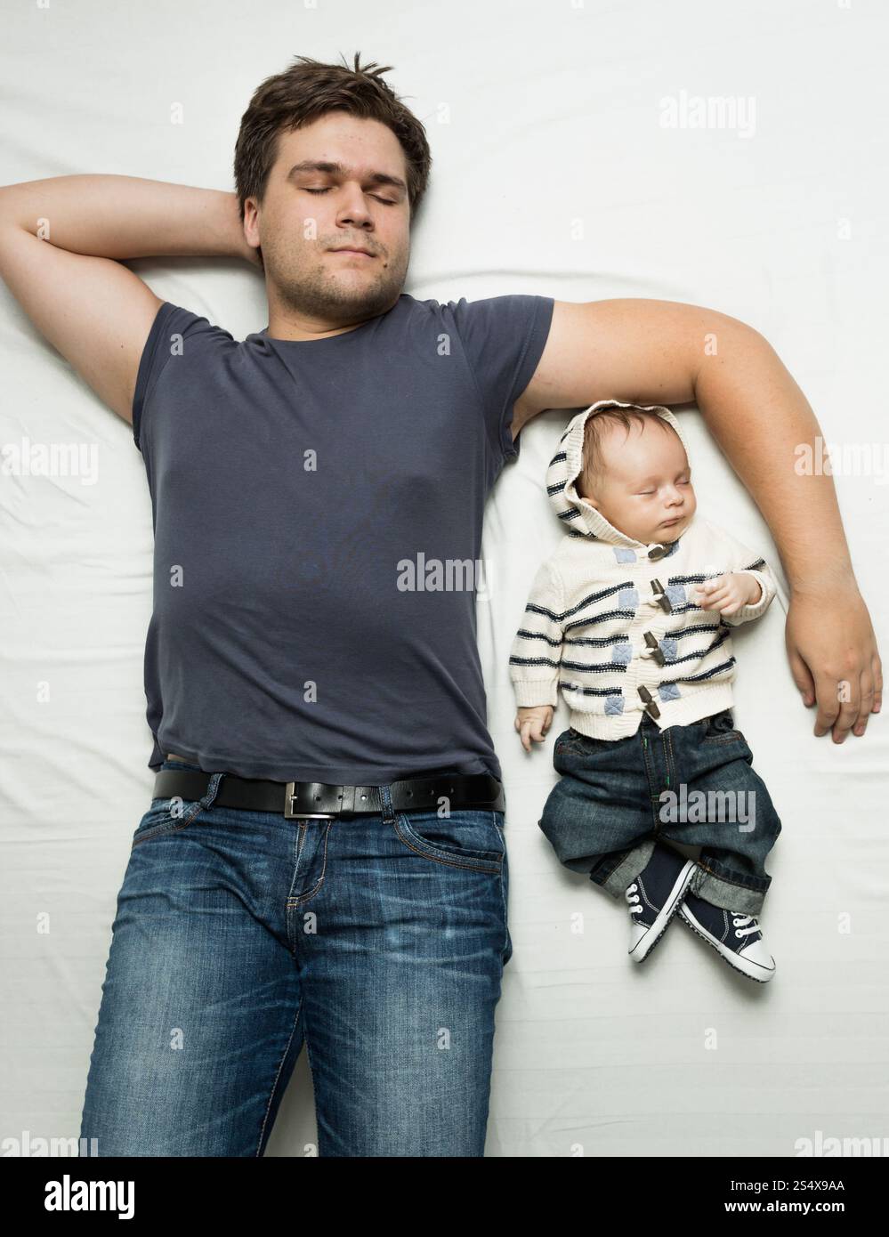 Vue de dessus portrait de Père élégant et baby boy sleeping on bed Banque D'Images