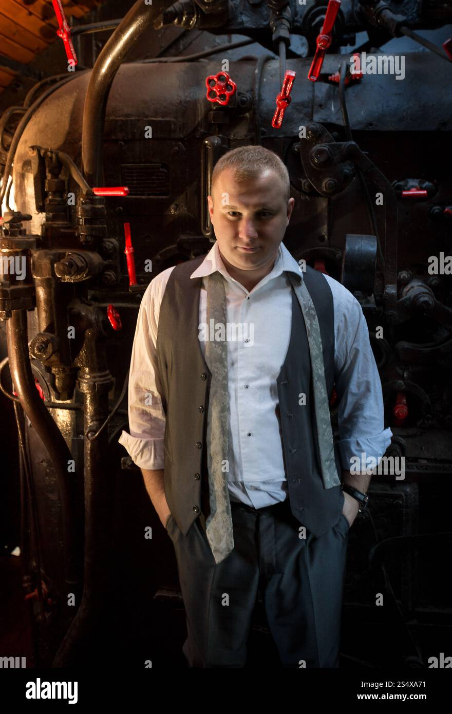 Portrait de l'homme confiant en costume rétro posing at four charbon locomotive Banque D'Images