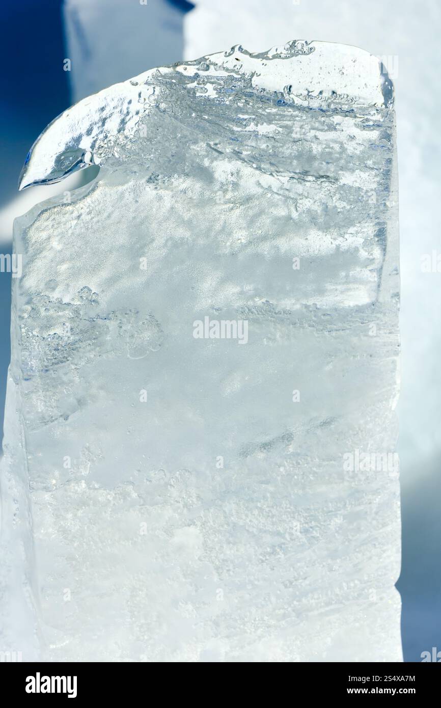 Haut transparent fusion morceau de glace éclairée par le soleil du printemps libre. Banque D'Images