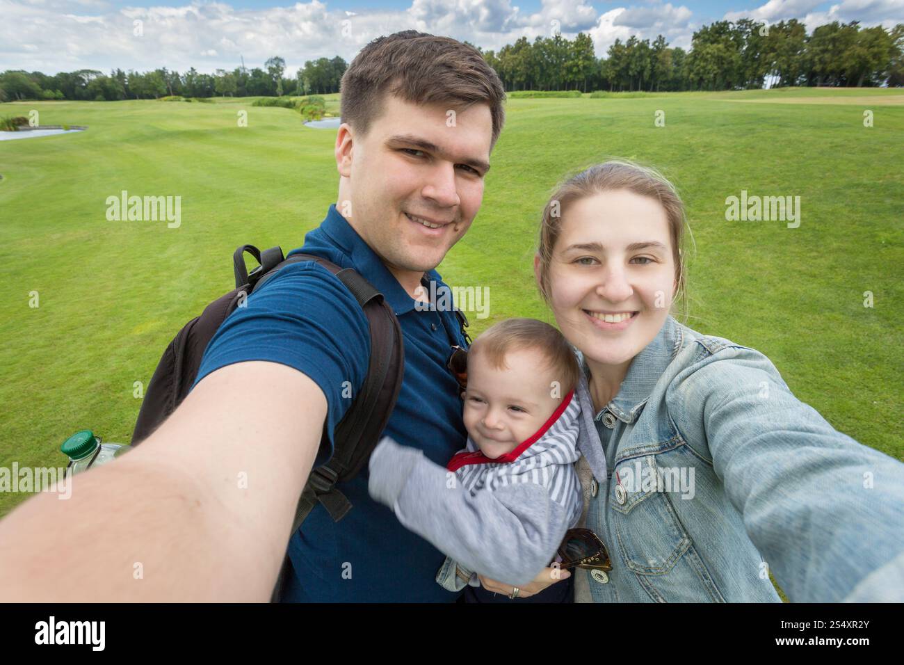 Image de selfies famille heureuse avec cute baby boy relaxing at park Banque D'Images