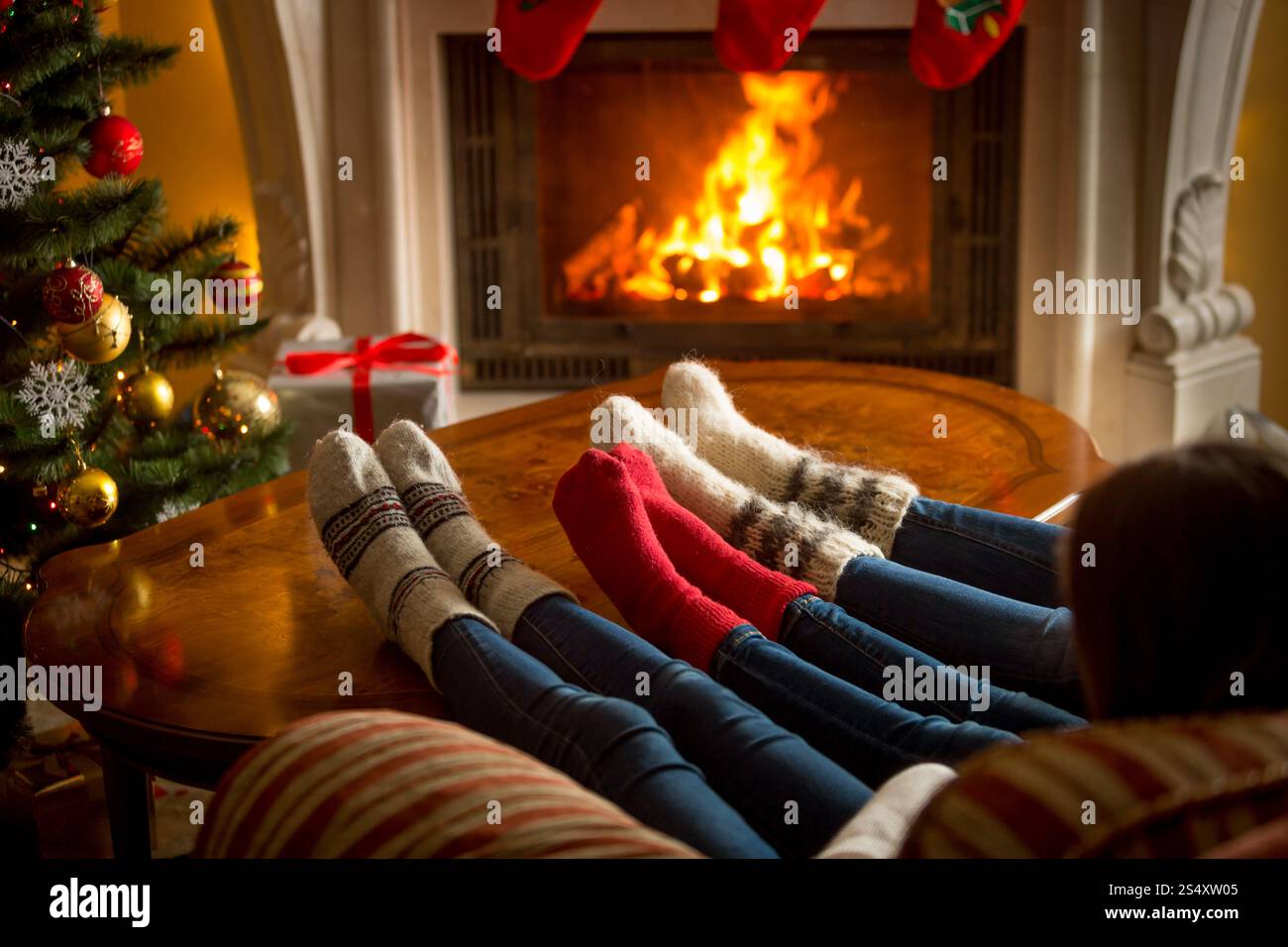 Pieds de famille en bas de laine près de réchauffement au foyer au salon à Noël Banque D'Images Pieds de famille en bas de laine près de réchauffement au foyer au salon à Noël Banque D'Images