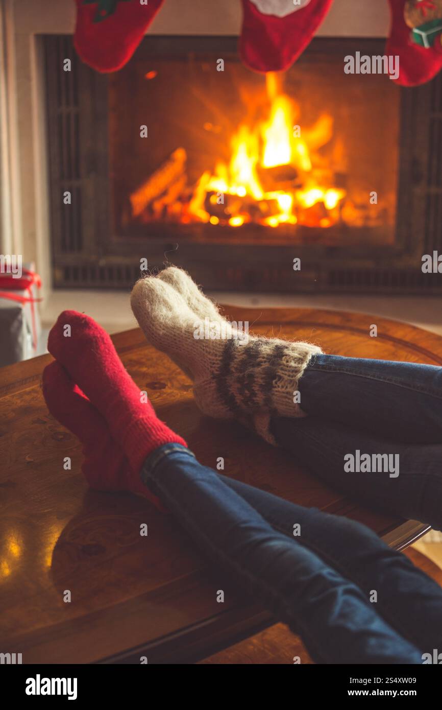 Image de ton couple wearing chaussettes de laine relaxant à la cheminée à Noël Banque D'Images Image de ton couple wearing chaussettes de laine relaxant à la cheminée à Noël Banque D'Images