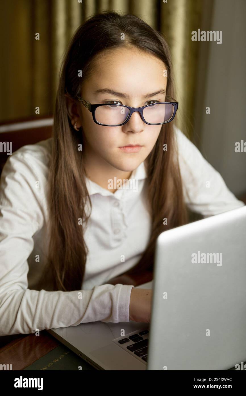 Closeup portrait of beautiful teen girl in eyeglasses using laptop Banque D'Images