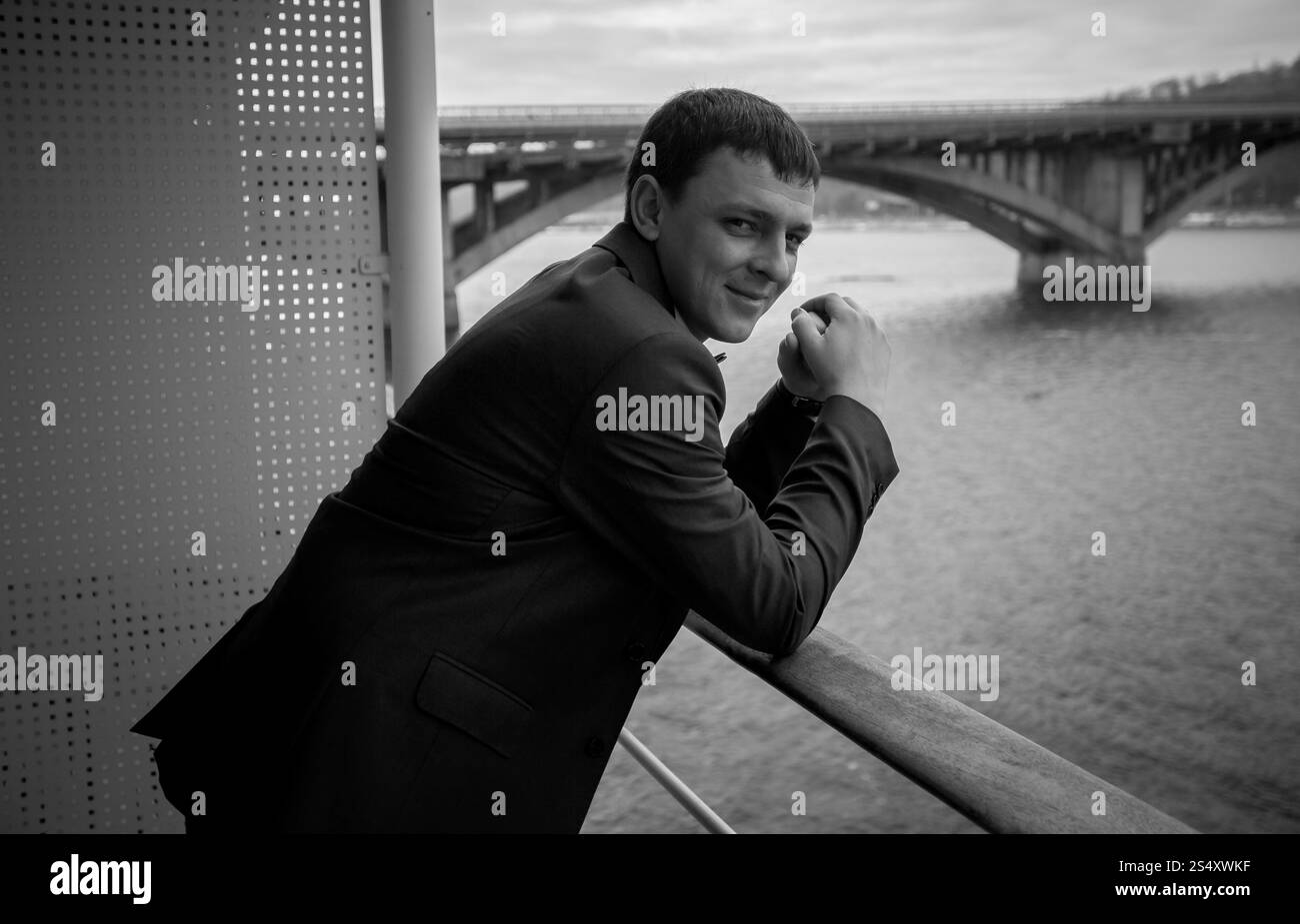 Le noir et blanc portrait of handsome businessman posing sur balcon Banque D'Images