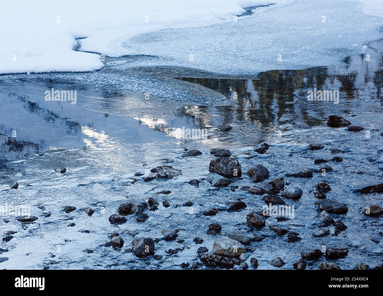 Reflet de pente enneigée dans l'eau avec la fonte des glaces. Banque D'Images