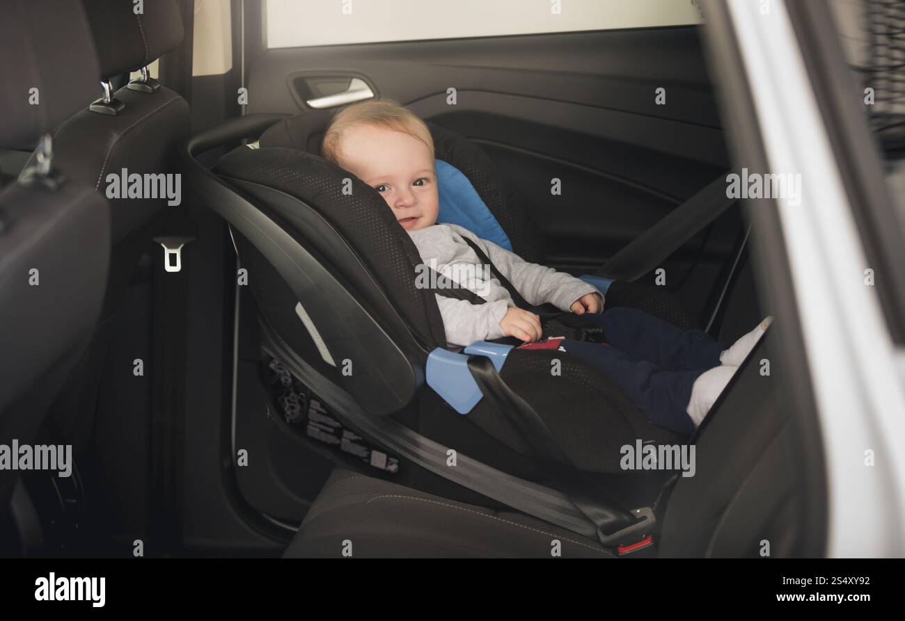 6 mois bébé garçon assis dans un siège d'auto pour enfant Banque D'Images