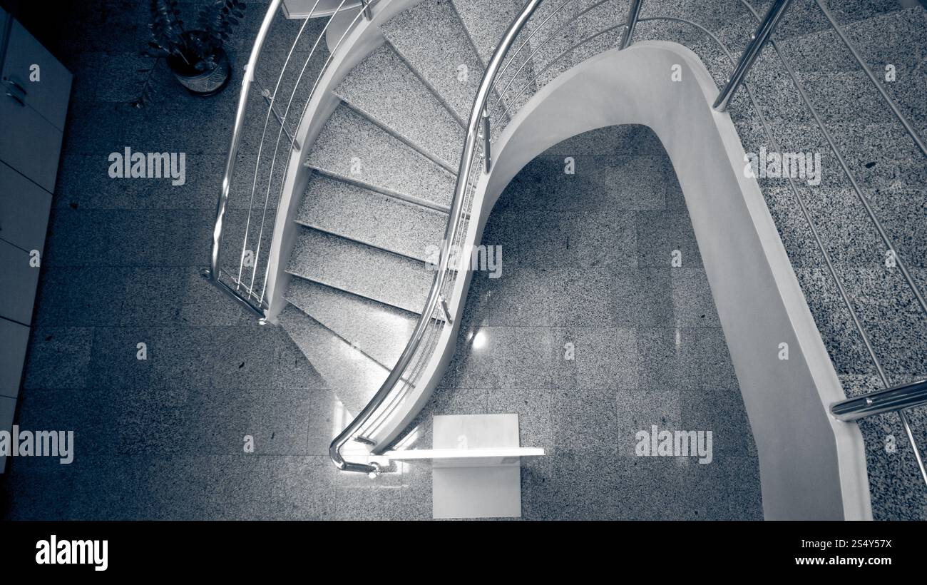 L'image monochrome aux couleurs de l'escalier de pierres incurvées au bâtiment moderne Banque D'Images