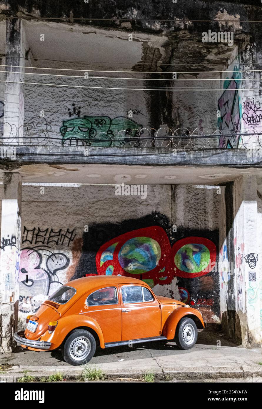 A n orange VW Beetle garé hors route à Santa Teresa, Rio de Janeiro, Brésil. Banque D'Images