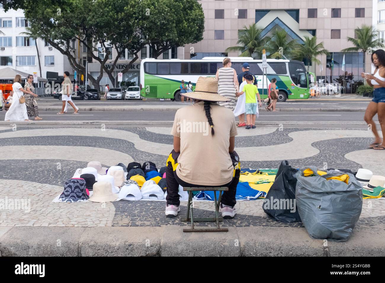 Un vendeur de rue est assis sur l'avenue Atlantica sur la plage de Copacabana, Rio de Janeiro, Brésil. Banque D'Images