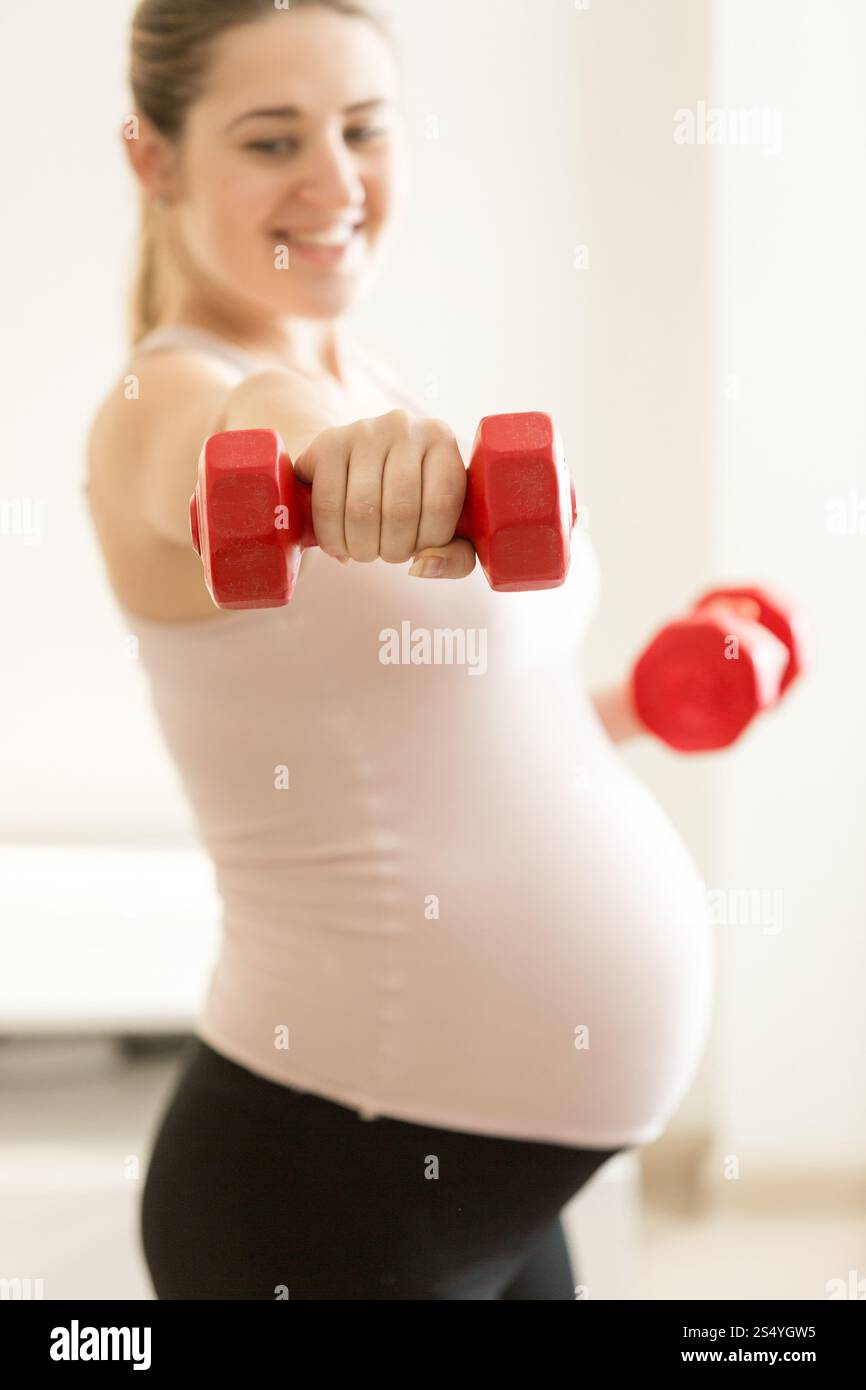 Portrait de femme enceinte exerçant avec des haltères Banque D'Images