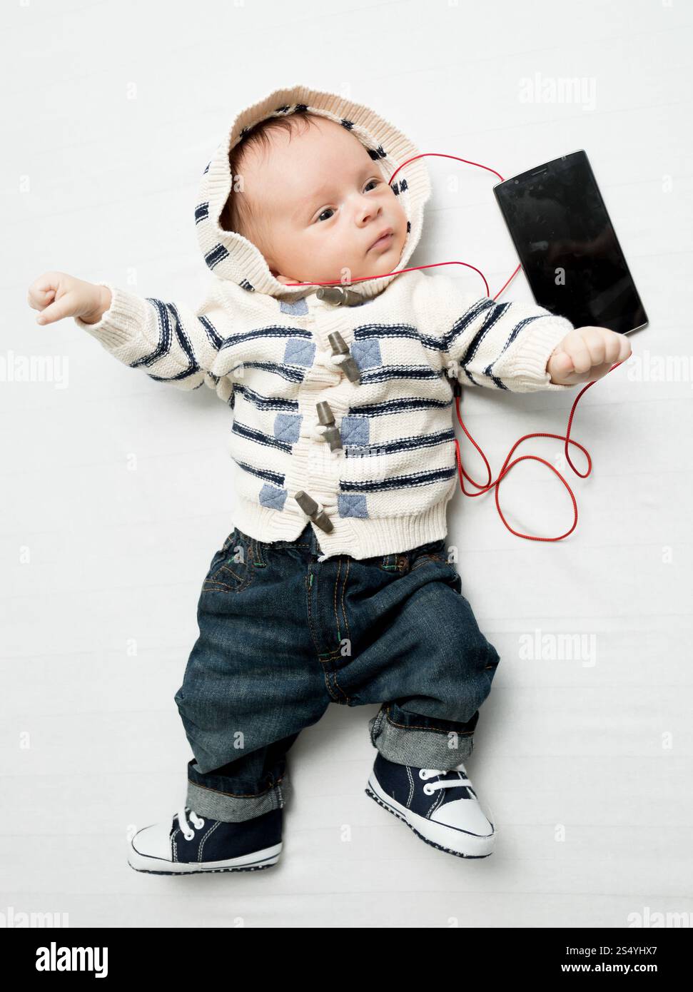 Mignon bébé garçon écoutant de la musique avec des écouteurs Banque D'Images