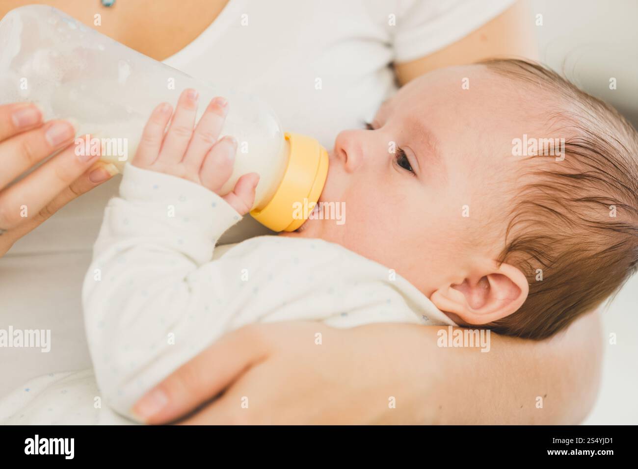 Portrait d'un bébé de 3 mois mangeant du lait de biberon Banque D'Images