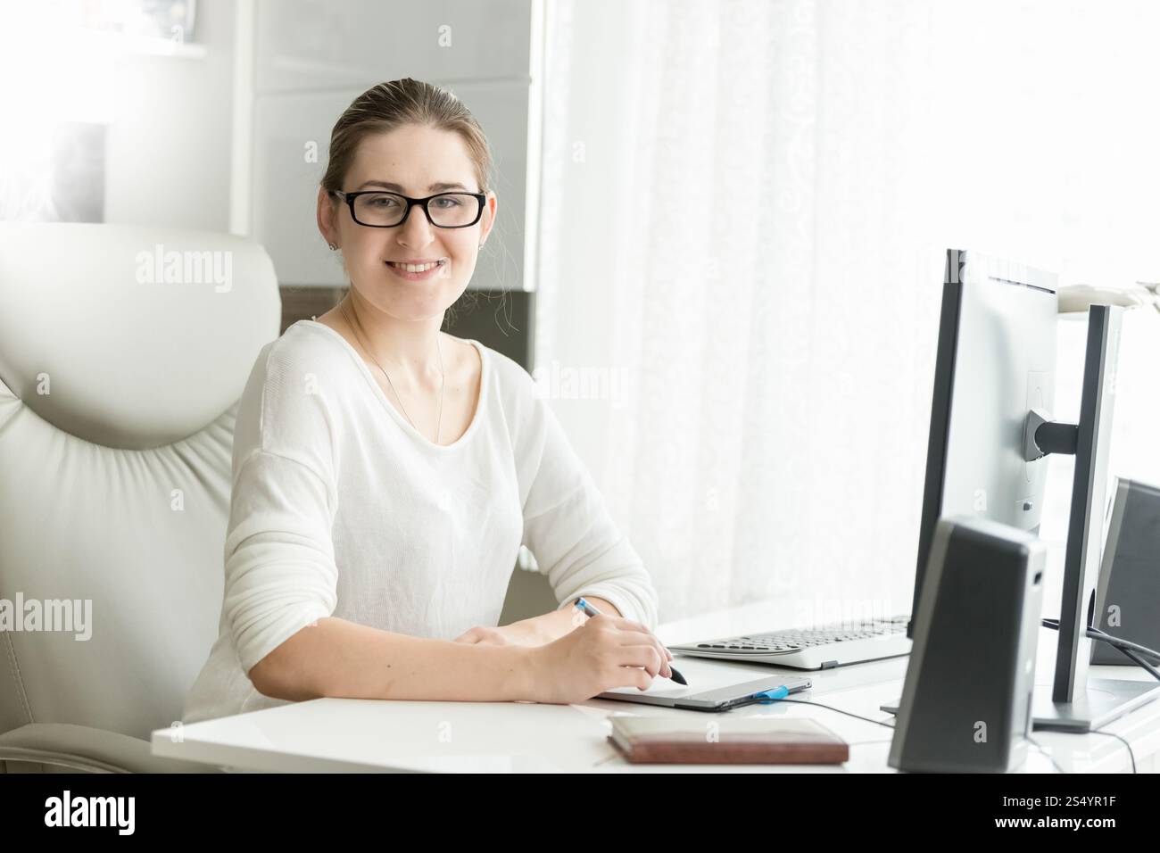 Portrait de designer féminin souriant travaillant au bureau Banque D'Images